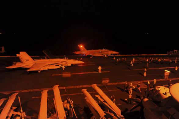 2 chiếc F-18 chuẩn bị cất cánh từ tàu sân bay USS George H.W. Bush tối 22-9. Ảnh: REUTERS