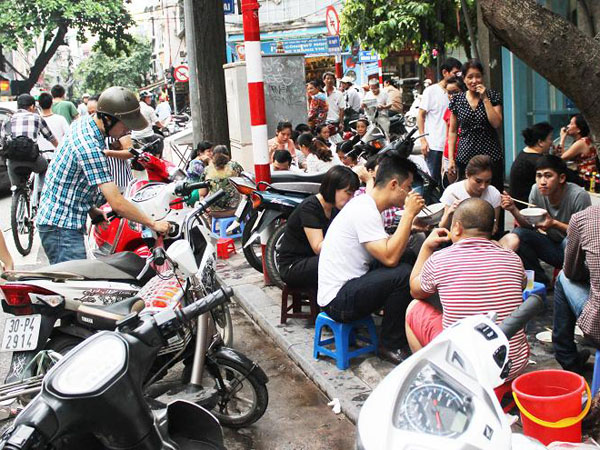 Ngồi ăn sát lề đường, cùng với xe cộ chật chội nhưng chẳng ai cảm thấy phiền hà