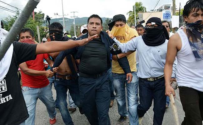 Một số người biểu t&igrave;nh qu&aacute; kh&iacute;ch bị cảnh s&aacute;t bắt giữ tại bang Guerrero. Ảnh: AP