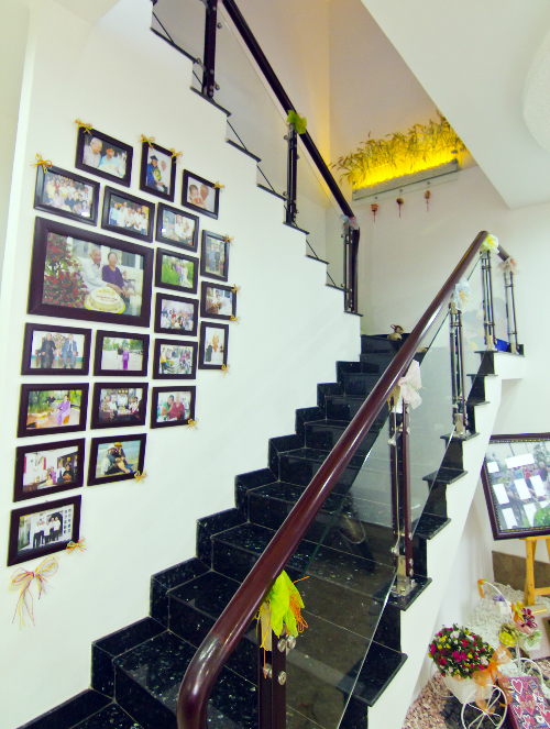 Kh&ocirc;ng gian quanh cầu thang được chăm ch&uacute;t với h&igrave;nh kỷ niệm của gia đ&igrave;nh. Nữ luật sư treo ảnh của tất cả những người th&acirc;n trong gia đ&igrave;nh th&agrave;nh h&igrave;nh nửa tr&aacute;i tim.
