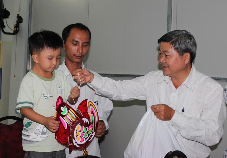 &Ocirc;ng Nguyễn Văn Dễ, Chủ tịch LĐLĐ quận B&igrave;nh T&acirc;n, TP HCM, tặng lồng đ&egrave;n cho con c&ocirc;ng nh&acirc;n kh&oacute; khăn ảnh: THANH NGA