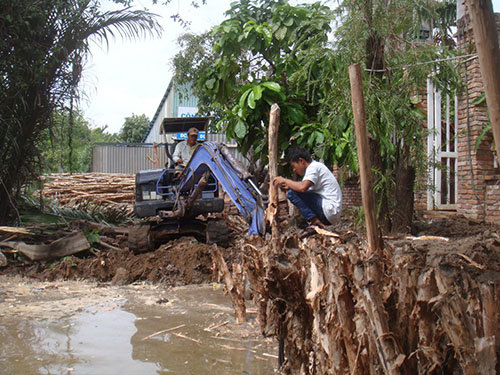 Bà Nguyễn Thị Nụ thuê máy xúc móc đất đã lấp rạch từ năm 2003 để trả lại sự thông thoáng cho dòng chảy