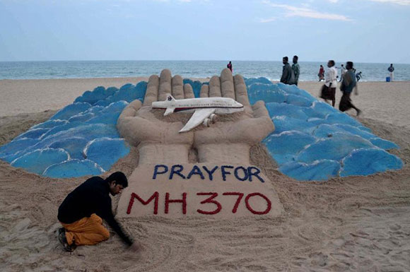 Nghệ sĩ đi&ecirc;u khắc c&aacute;t Sudarshan Pattnaik b&ecirc;n t&aacute;c phẩm cầu nguyện cho chuyến bay mất t&iacute;ch MH370 tr&ecirc;n b&atilde;i biển ở Puri - Ấn Độ. Ảnh: Stringer