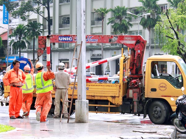 C&ocirc;ng nh&acirc;n th&aacute;o dỡ c&aacute;c biển b&aacute;o tr&ecirc;n c&aacute;c tuyến đường L&ecirc; Lợi, Nguyễn Huệ chiều ng&agrave;y 22-7