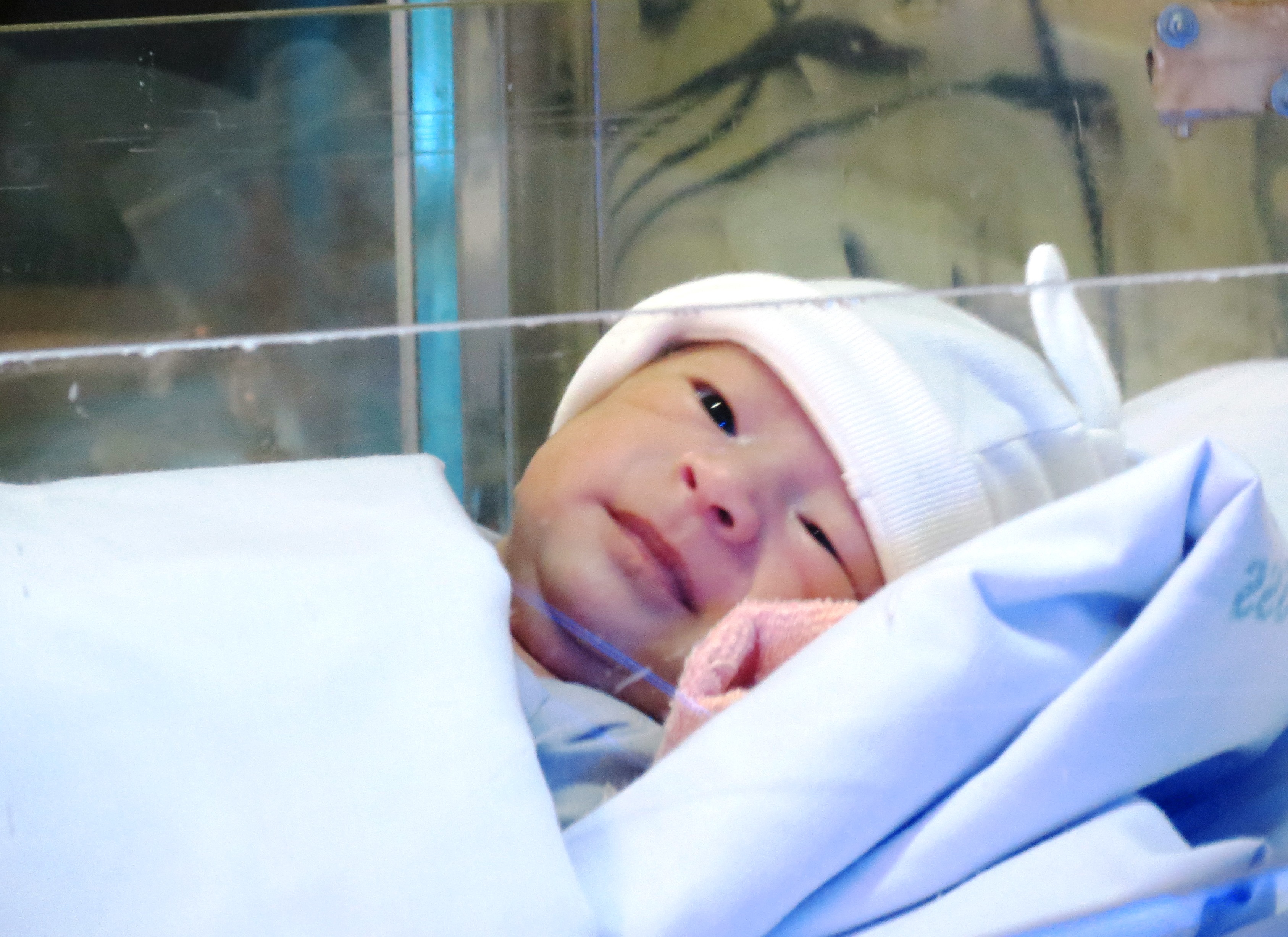 Cháu bé mỉm cười tinh nghịch với một điều dưỡng của khoa Hồi sức sơ sinh