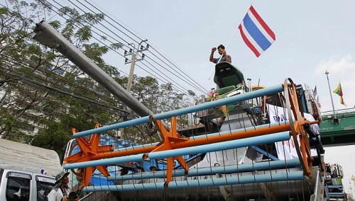 N&ocirc;ng d&acirc;n vẫy cờ tr&ecirc;n chiếc m&aacute;y gặt đập trước trụ sở Bộ Thương mại. Ảnh: Reuters
