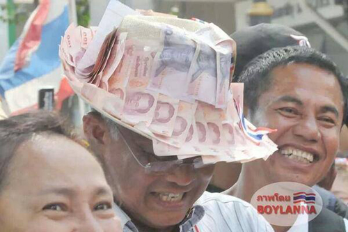 &Ocirc;ng Suthep đội chiếc n&oacute;n d&aacute;n đầy tiền ng&agrave;y 7-2. Ảnh: Blue Sky Channel