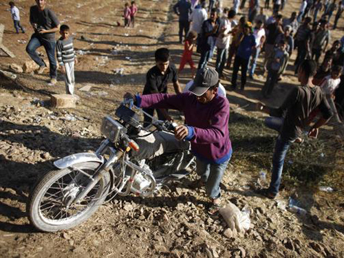 Một người Kurd ở Syria “ôm” xe trốn chạy sang Thổ Nhĩ Kỳ Ảnh: REUTERS