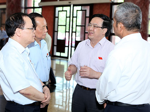 Các đại biểu trao đổi bên hành lang Quốc hội sau khi nghe tờ trình về dự án Luật Nhà ở (sửa đổi)Ảnh: Thế Dũng
