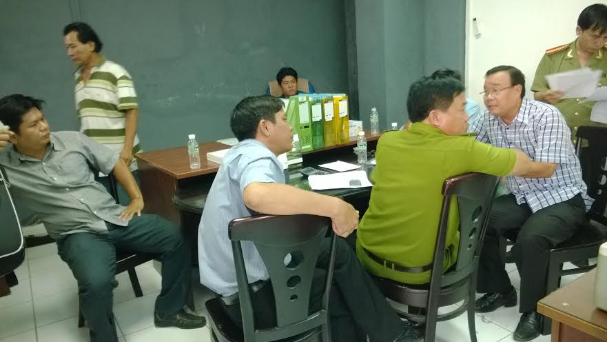 &Ocirc;ng Nguyễn Hữu Nghĩa, chủ nh&agrave; xưởng (b&igrave;a phải), đang tr&igrave;nh b&agrave;y sự việc với c&aacute;c cơ quan chức năng quận 12, TP HCM