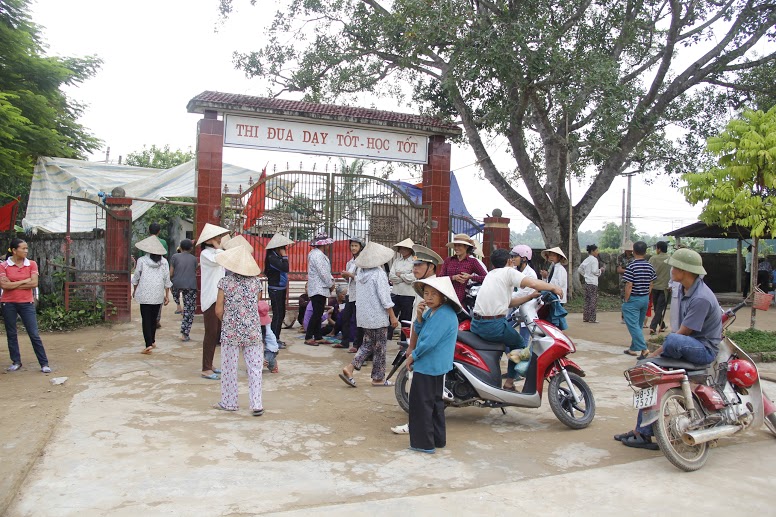 Người d&acirc;n tụ tập trước cổng Trường THCS Hương B&igrave;nh để phản đối việc s&aacute;p nhập trường.