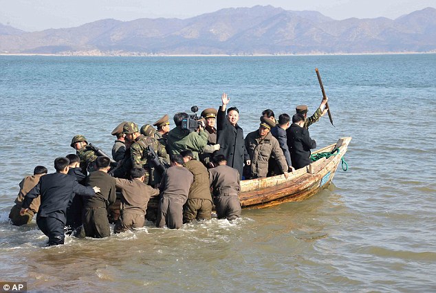 Ahoy! Kim waves at military officers after inspecting the Wolnae Islet Defense Detachment, North Korea, near the western sea border with South Korea in March 2013