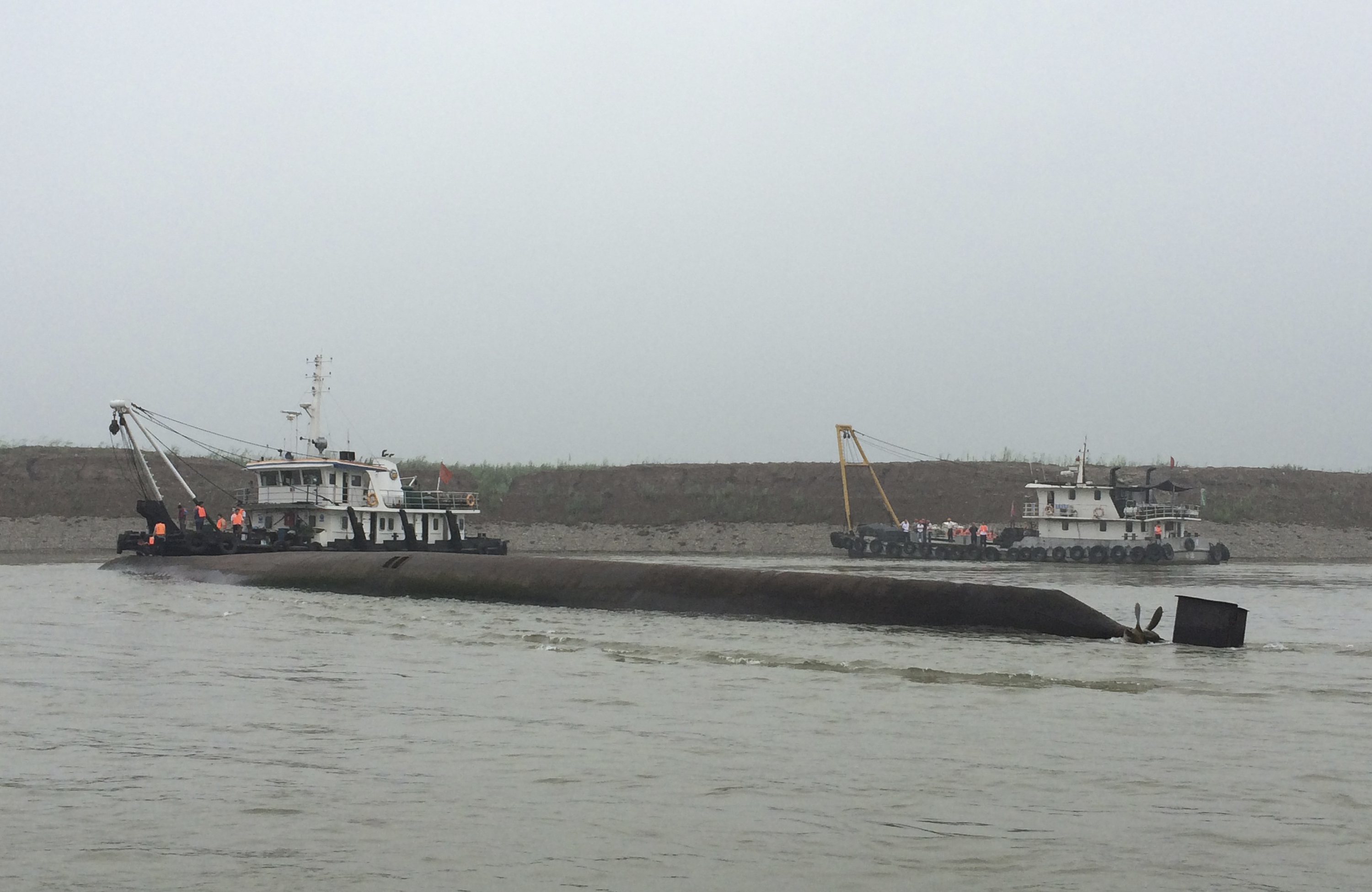 Rescue workers arrive near the capsized ship, center, on the Yangtze River in central Chinas Hubei province Tuesday, June 2, 2015. The small...
