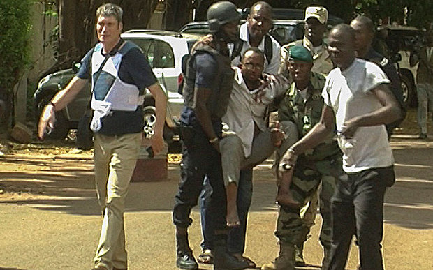 An injured hostage is carried by security forces from the Radisson Hotel, Bamako, Mali, 20 November 2015.
