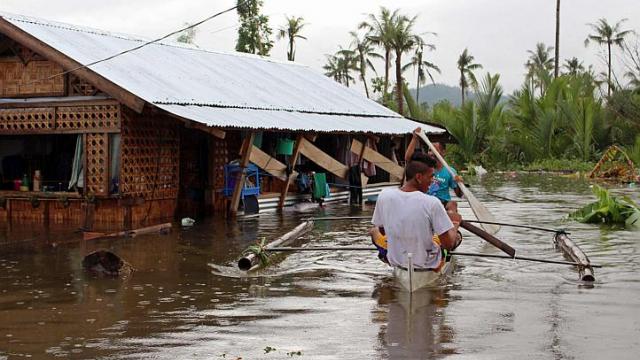 Người d&acirc;n tại thị trấn Palo, tỉnh Samar, Philippines chống trọi với lũ lụt. Ảnh Reuters