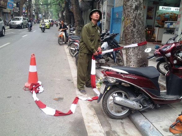 Công nhân dùng dây phong toả quanh khu vực chặt cây, đảm bảo an toàn cho người dân