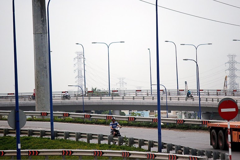 Một người điều khiển xe m&aacute;y di chuyển từ cầu vượt C&aacute;t L&aacute;i qua đường Mai Ch&iacute; Thọ