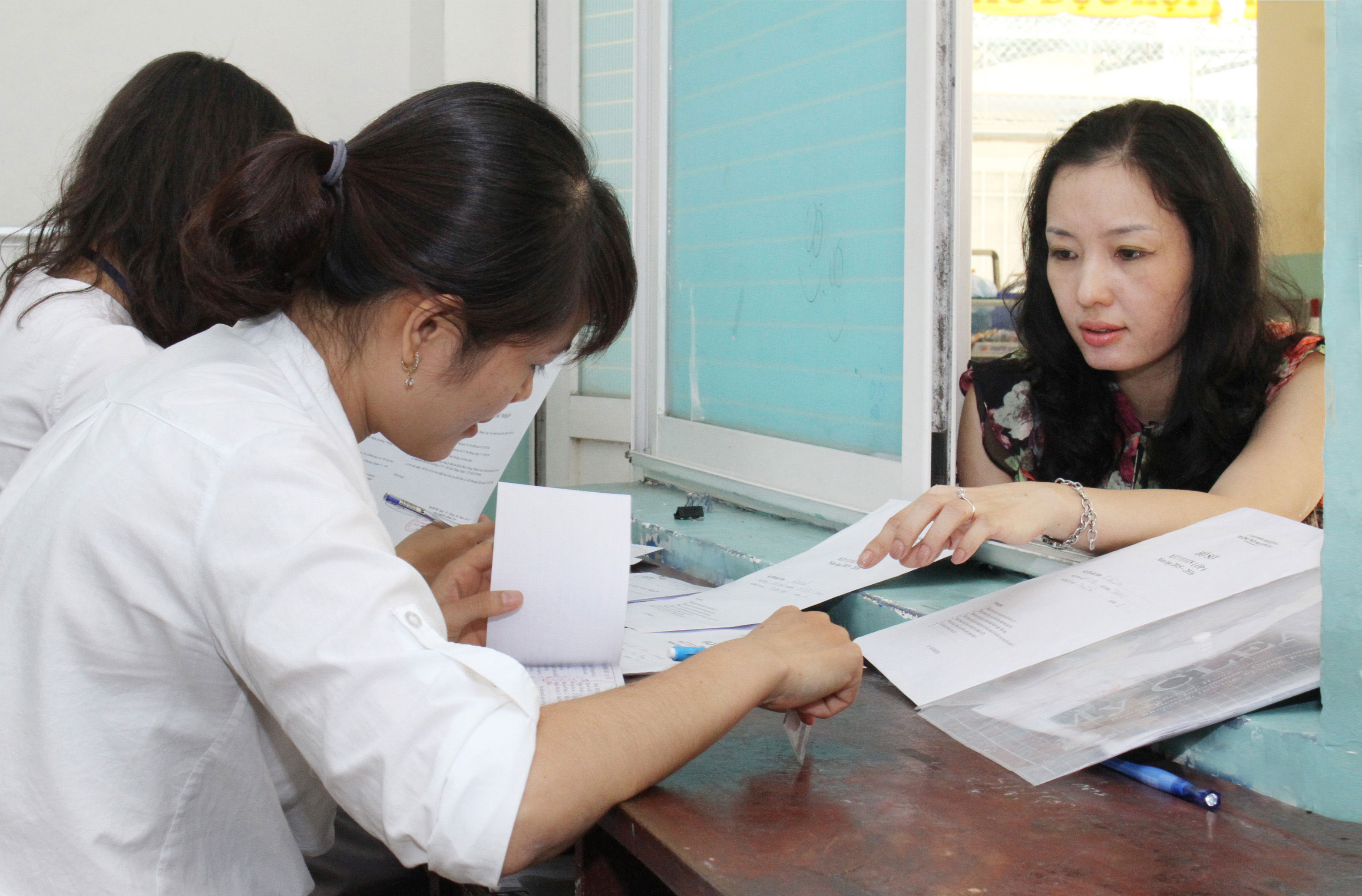 Phụ huynh nộp hồ sơ x&eacute;t tuyển v&agrave;o lớp 6 Trường THCS Nguyễn Du (quận 1, TP HCM) Ảnh: HO&Agrave;NG TRIỀU