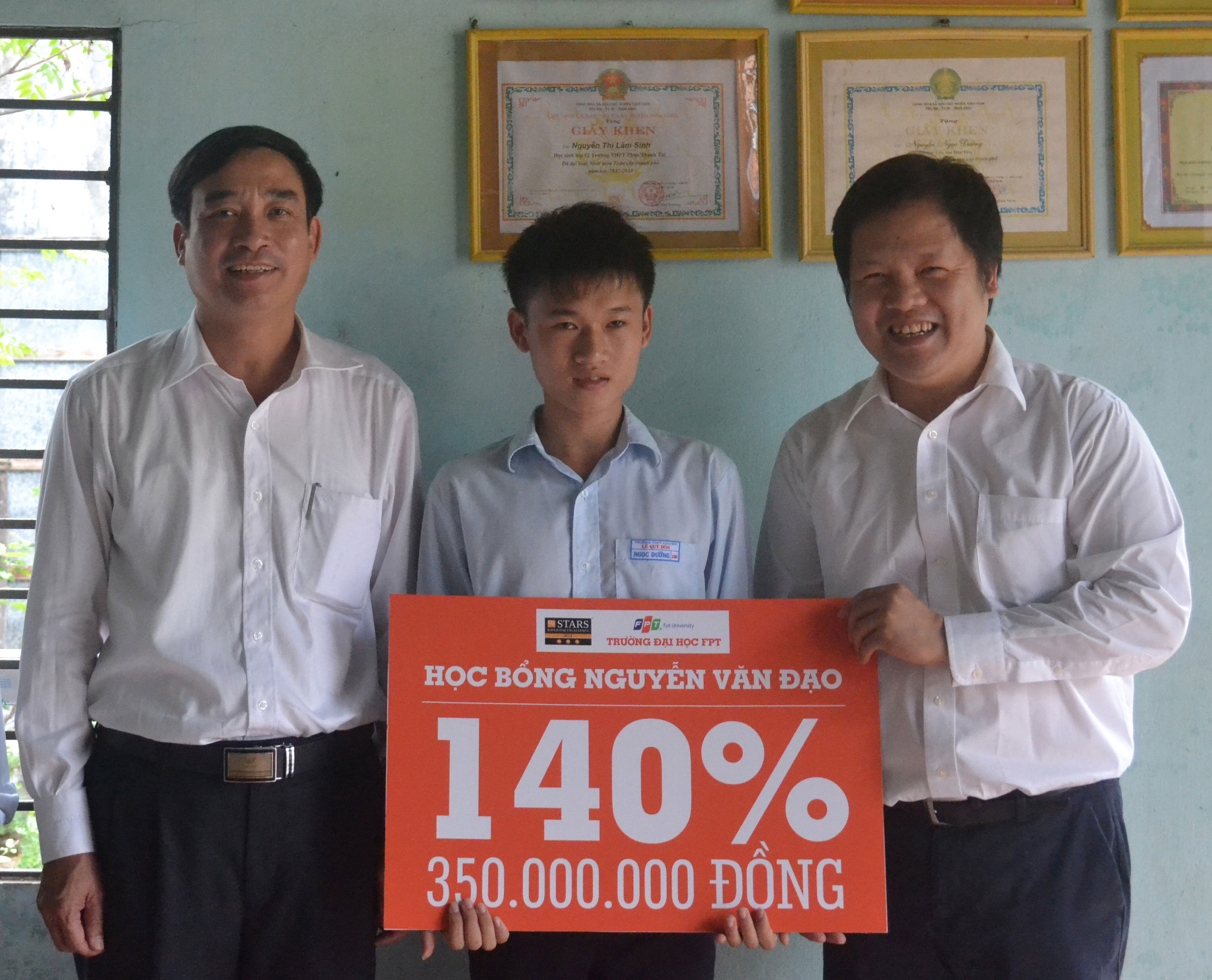 Ông Đàm Quang Minh, Hiệu trưởng Trường ĐH FPT (bìa phải) và Giám đốc Sở GD-ĐT Đà Nẵng, ông Lê Trung Chinh, trao học bổng cho em Nguyễn Ngọc Dưỡng Ảnh: HỒNG QUANG