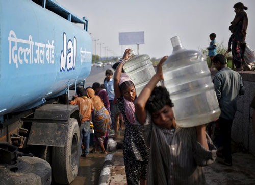 Người d&acirc;n Delhi được ph&acirc;n ph&aacute;t nước uống Ảnh: REUTERS