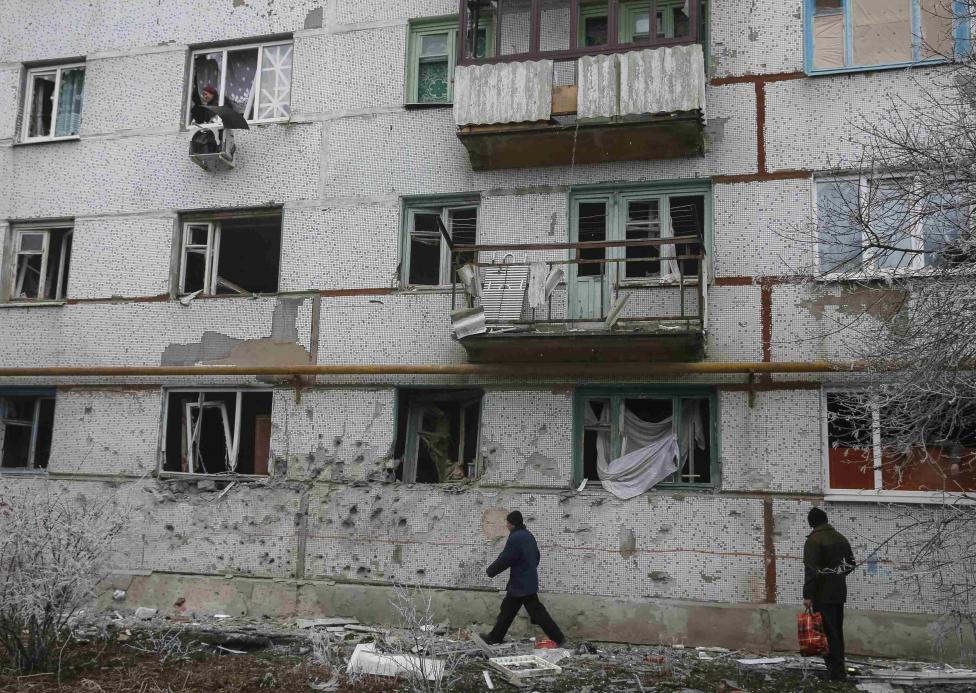 Cư d&acirc;n Svitlodarsk ở miền Đ&ocirc;ng Ukraine b&ecirc;n ngo&agrave;i những t&ograve;a nh&agrave; tan hoang. Ảnh: Reuters