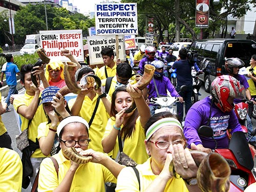 Người d&acirc;n Philippines tuần h&agrave;nh phản đối trước L&atilde;nh sự qu&aacute;n Trung Quốc ở TP Makati h&ocirc;m 24-7 Ảnh: REUTERS