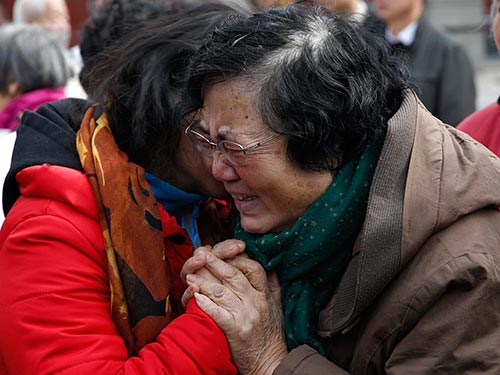 Người thân của những hành khách trên chuyến bay MH370 an ủi nhau tại buổi lễ tưởng niệm ở thủ đô Bắc Kinh - Trung Quốc hôm 8-3 Ảnh: REUTERS