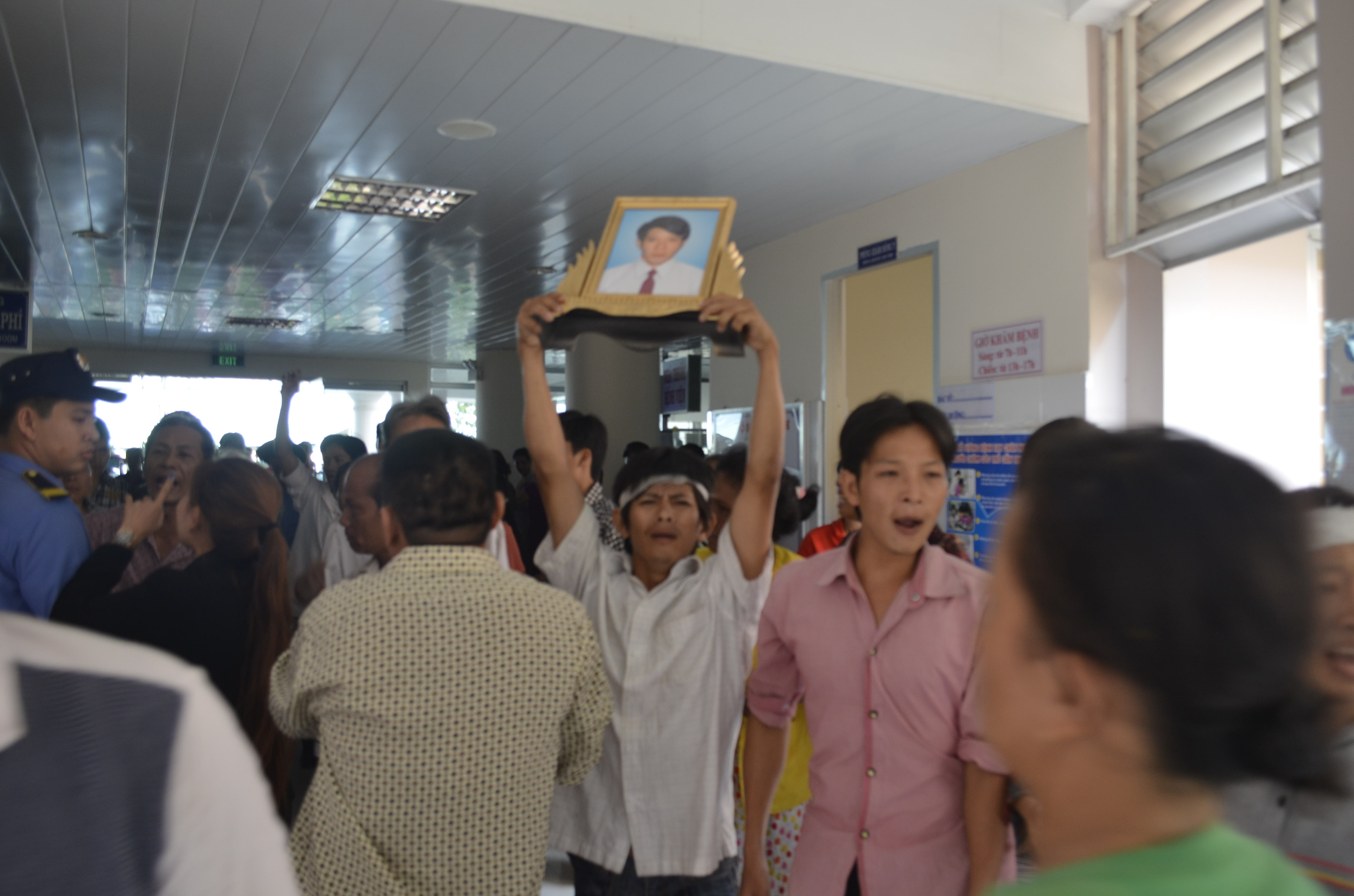 Người nh&agrave; mang di ảnh anh Sang đến bệnh viện.