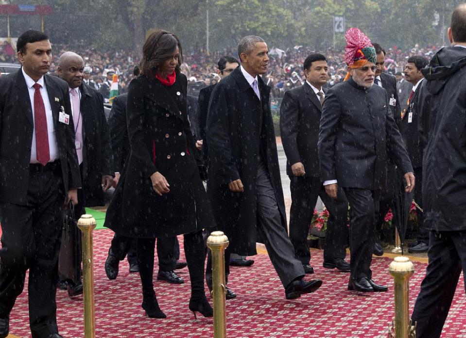 Vợ chồng Tổng thống Obama bất chấp trời mưa vẫn ngồi dự lễ. Ảnh: Reuters