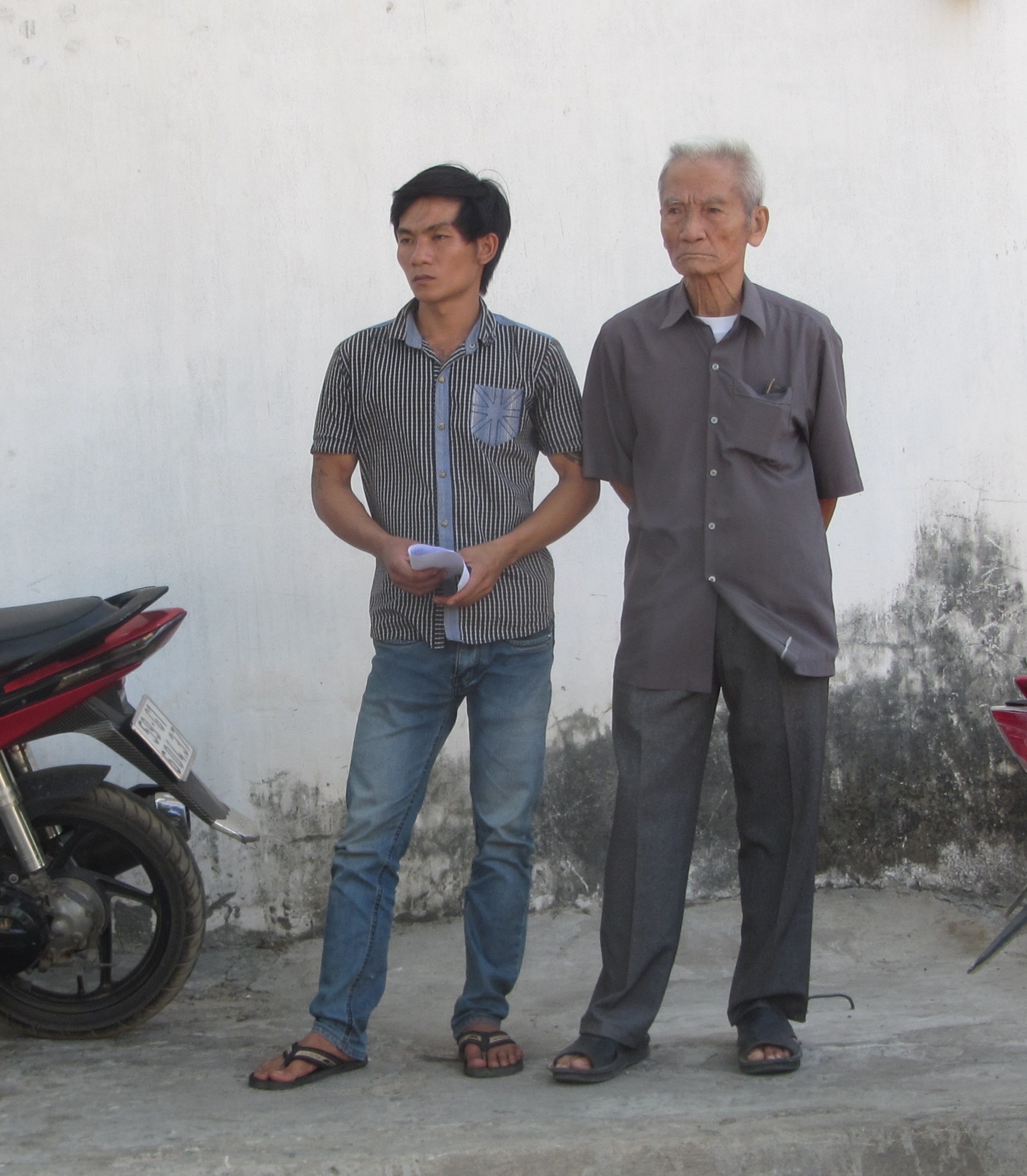 &Ocirc;ng Truyện (b&ecirc;n phải) v&agrave; con của bị can Huỳnh Văn N&eacute;n lặng người khi nhận thư trả lời kh&ocirc;ng chấp nhận cho tại ngoại của cơ quan CSĐT.
