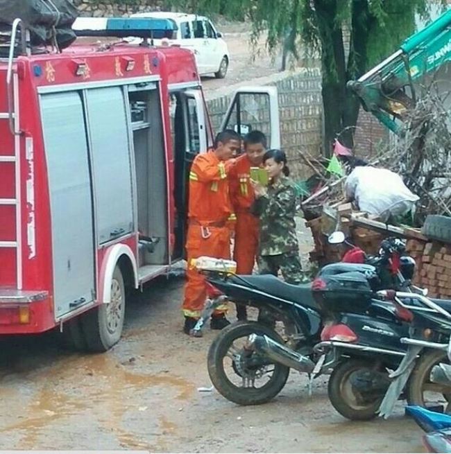Ba l&iacute;nh cứu hỏa t&uacute;m tụm đứng chụp h&igrave;nh... Ảnh: The Nanfang