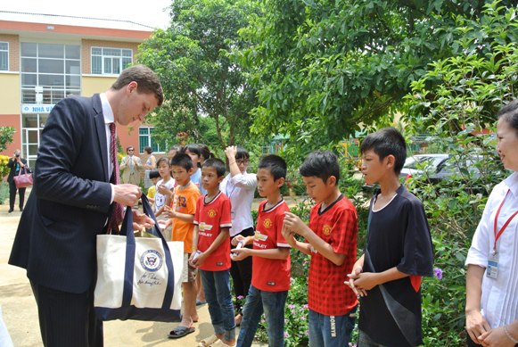 Những người đi c&ugrave;ng phu nh&acirc;n chia qu&agrave; cho c&aacute;c em ở trại trẻ