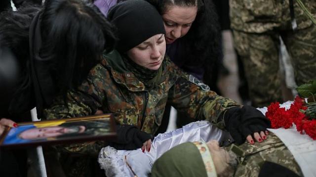 Một nữ qu&acirc;n nh&acirc;n Ukraine tại đ&aacute;m tang cha m&igrave;nh, người tử trận ở Luhansk. Đ&aacute;m tang được tổ chức ở Kiev h&ocirc;m 20-1. Ảnh: REUTERS