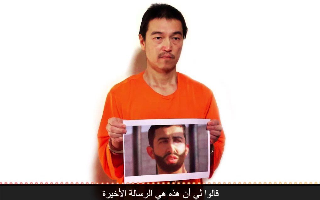 Hình ảnh nhà báo Goto cầm ảnh chân dung phi công người Jordan trong đoạn video mới công bố. Ảnh: NY Times