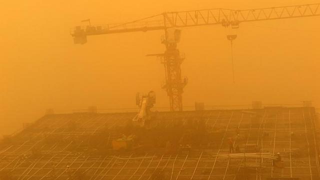 C&ocirc;ng nh&acirc;n vẫn l&agrave;m việc tr&ecirc;n n&oacute;c một t&ograve;a nh&agrave; ở Dubai. Ảnh: EPA
