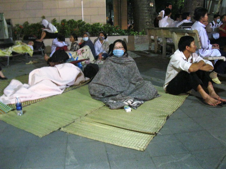 H&agrave;ng trăm b&ecirc;̣nh nh&acirc;n v&agrave; người nh&agrave; được sơ t&aacute;n khẩn cấp nằm la li&ecirc;̣t tại s&acirc;n và ti&ecirc;̀n sảnh của b&ecirc;̣nh vi&ecirc;̣n Bạch Mai