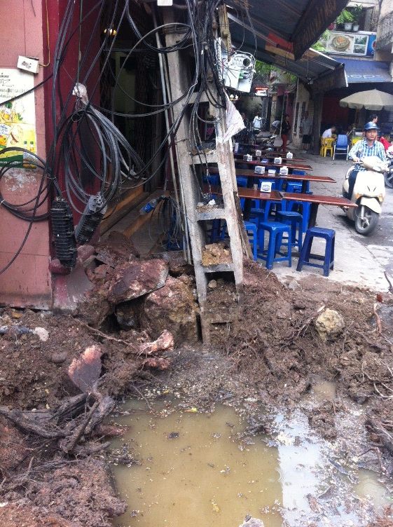 Cây xà cừ trồng ngay sát cống thoát nước. Cây cột điện cạnh cây xà cừ cũng đã bị nghiêng