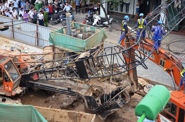 Chi&ecirc;́c máy xúc bị c&acirc;̀n c&acirc;̉u đè phải