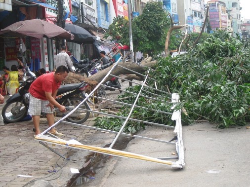 M&ocirc;̣t người d&acirc;n tại đường Trường Chinh với tấm bảng quảng cáo bị xé tan sau cơn l&ocirc;́c