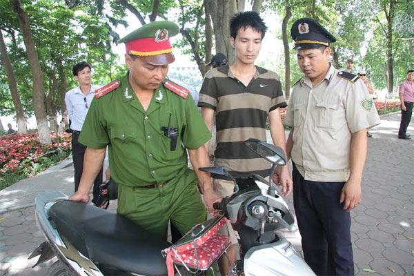 Sau khi l&ecirc;n bờ, nam thanh ni&ecirc;n (ở giữa) được đưa về C&ocirc;ng an phường H&agrave;ng Trống xử l&yacute;