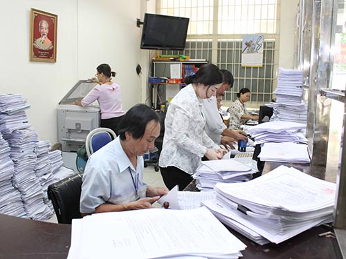 Đến cuối năm 2021, TP HCM phải giảm tối thiểu 10% số bi&ecirc;n chế được giao. Trong ảnh: C&aacute;n bộ UBND phường Bến Ngh&eacute;, quận 1, TP HCM giải quyết hồ sơ cho người d&acirc;n Ảnh: HO&Agrave;NG TRIỀU
