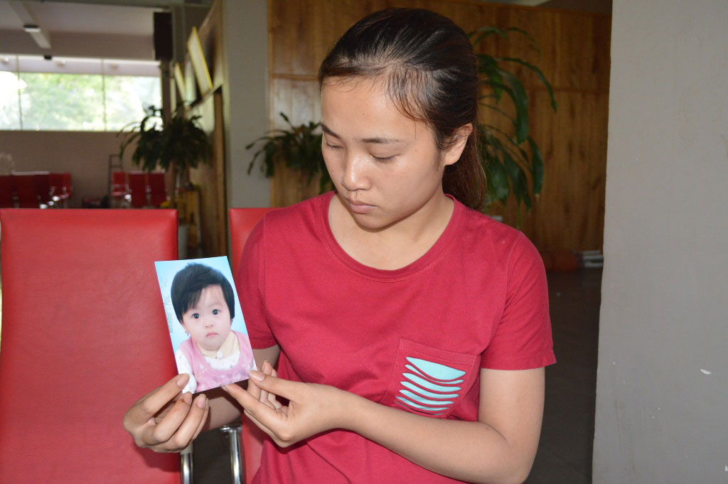 Chị B&ugrave;i Thị Th&uacute;y L&ecirc; b&ecirc;n di ảnh của b&eacute; Trần Ho&agrave;ng Kim Anh
