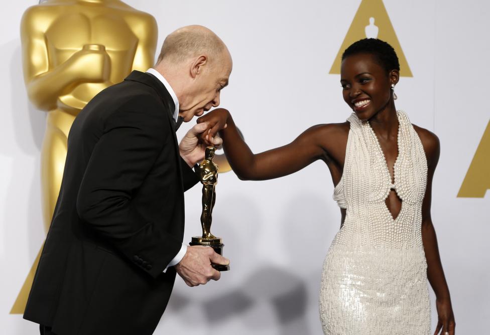 J.K. Simmons, chiến thắng hạng mục Nam diễn vi&ecirc;n phụ xuất sắc nhất đ&atilde; h&ocirc;n l&ecirc;n tay của Lupita Nyongo sau khi nhận tượng v&agrave;ng