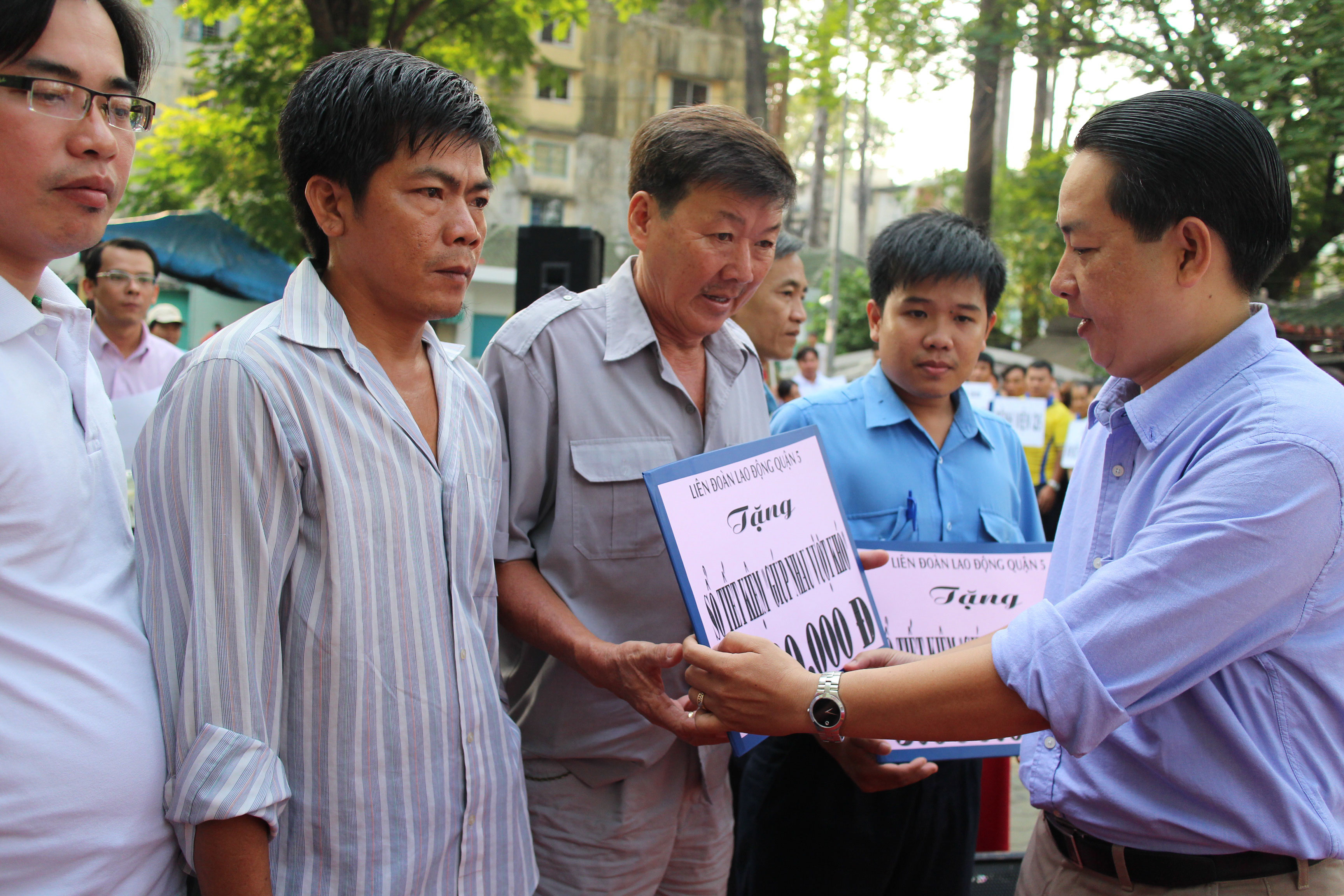 Ông Kiều Ngọc Vũ, Phó Chủ tịch LĐLĐ TP HCM, trao sổ tiết kiệm cho CNVC-LĐ bị bệnh hiểm nghèo tại quận 5, TP HCM