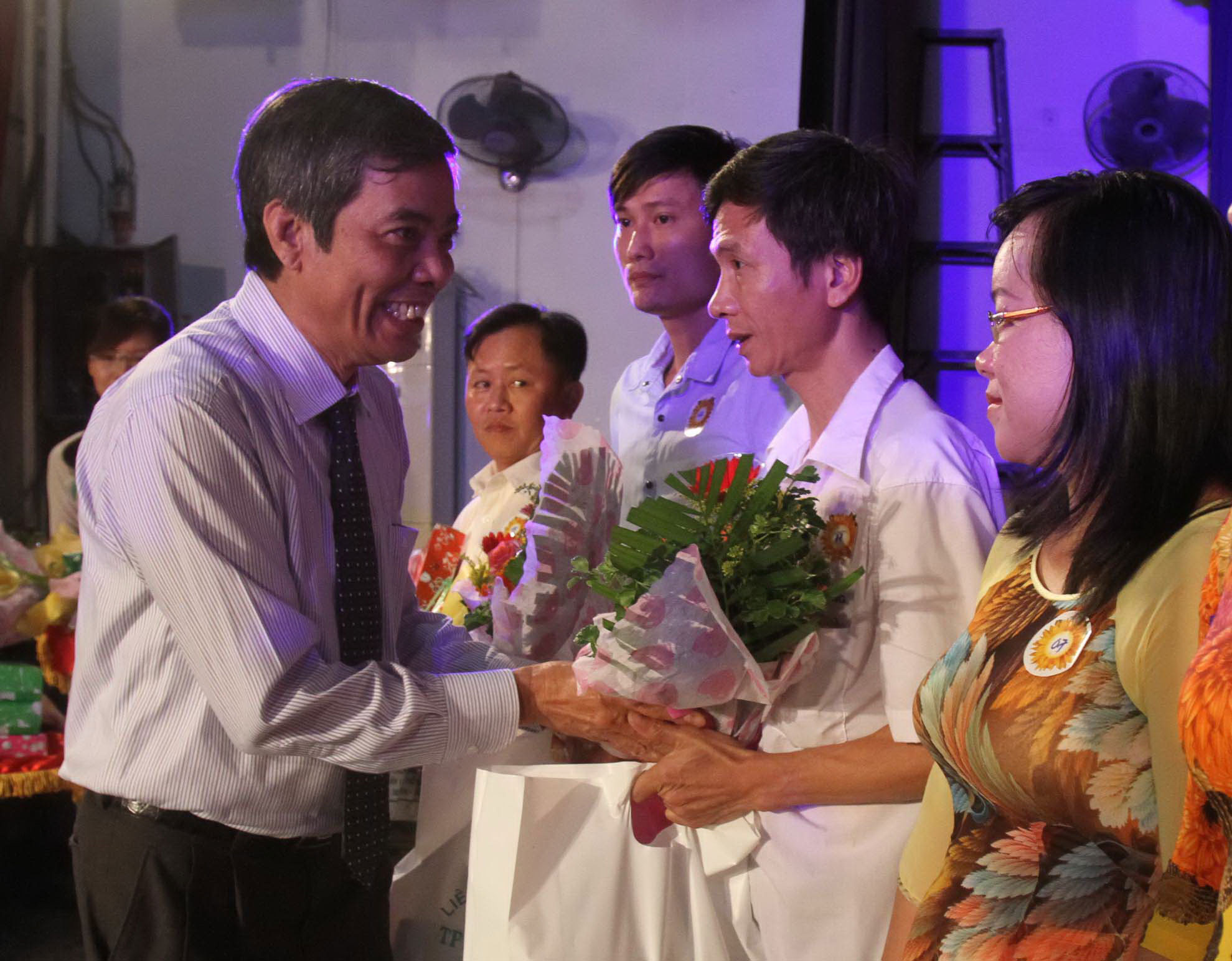 Ông Nguyễn Văn Khải, Phó Chủ tịch Thường trực LĐLĐ TP HCM, tặng hoa chúc mừng các gia đình tiêu biểu Ảnh: HOÀNG TRIỀU