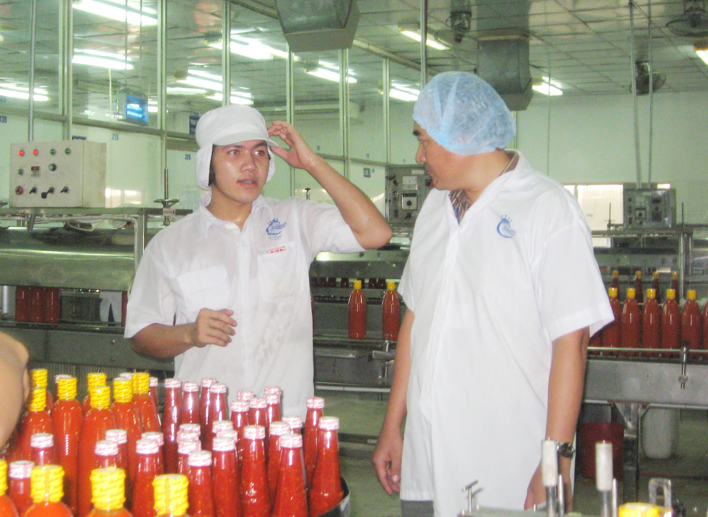 Anh Huỳnh Đại Tr&iacute; (b&igrave;a phải) - Gi&aacute;m đốc Xưởng Cơ kh&iacute; - Bảo tr&igrave;, Chủ tịch C&ocirc;ng đo&agrave;n C&ocirc;ng ty CP Thực phẩm Cholimex - lu&ocirc;n s&aacute;t c&aacute;nh với anh em c&ocirc;ng nh&acirc;n  Ảnh: THANH NGA