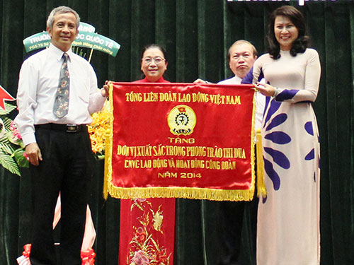Ông Đặng Ngọc Tùng, Chủ tịch Tổng LĐLĐ Việt Nam, trao cờ thi đua xuất sắc của Tổng LĐLĐ Việt Nam cho tập thể Thường trực LĐLĐ TP HCM Ảnh: HOÀNG TRIỀU