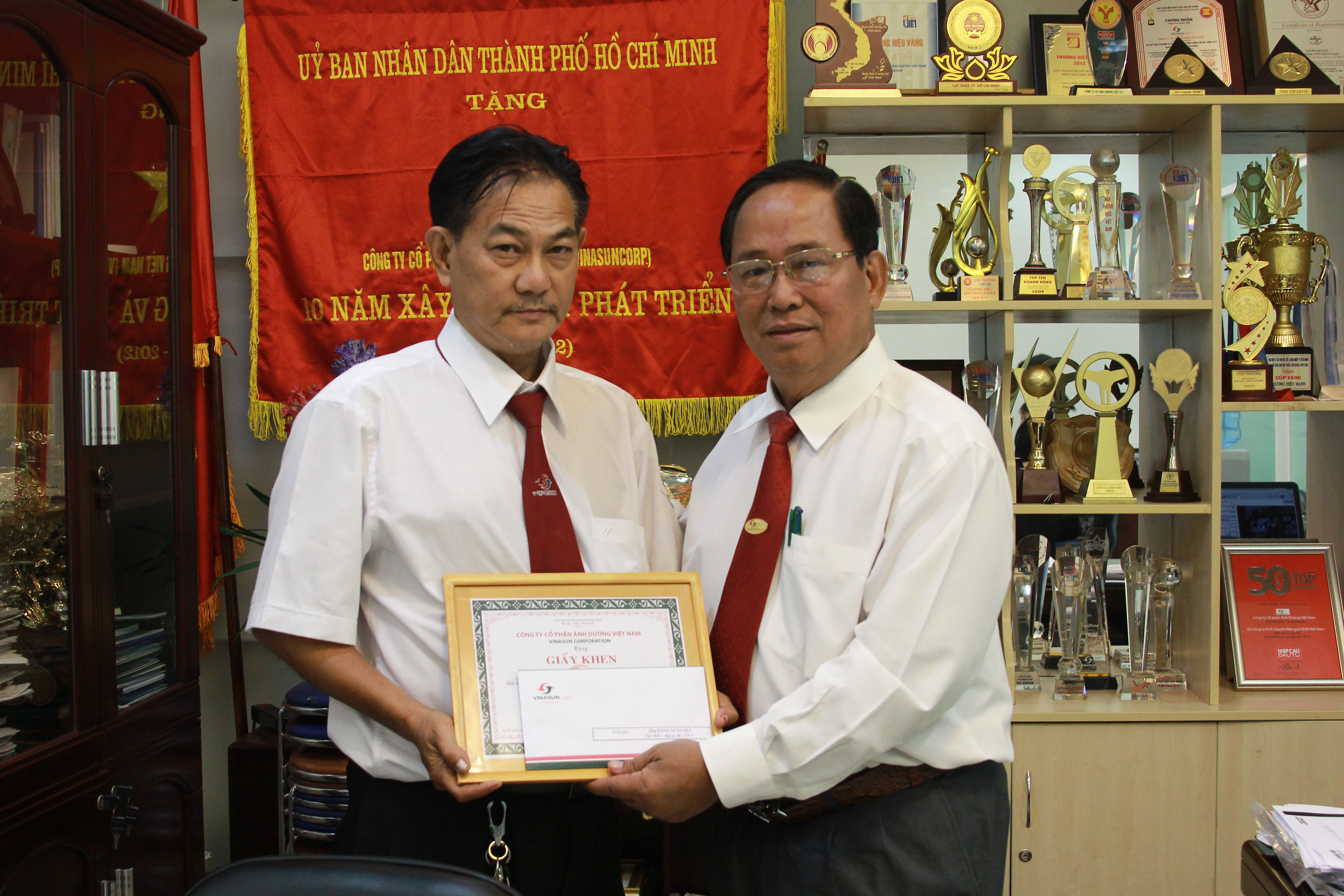 &Ocirc;ng Tạ Long Hỷ (b&ecirc;n phải), Ph&oacute; Tổng Gi&aacute;m đốc Thường trực ki&ecirc;m Gi&aacute;m đốc Taxi Vinasun, tặng giấy khen cho t&agrave;i xế Đặng Xu&acirc;n Tr&agrave;