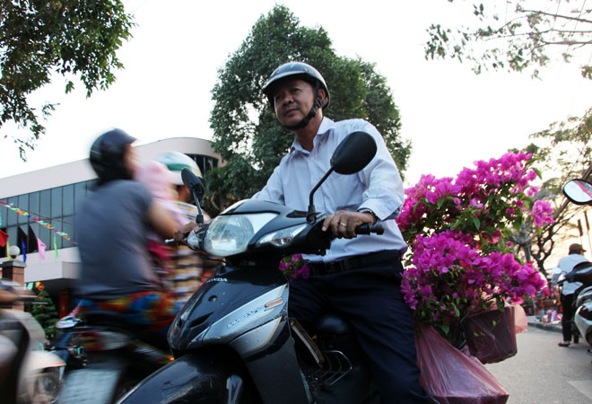 &Ocirc;ng Huỳnh Lựu (ngụ quận 4) tranh thủ mua 6 chậu b&ocirc;ng giấy, với gi&aacute; 50.000 đồng/chậu để về chưng Tết.