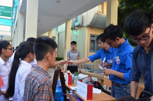 Những sinh vi&ecirc;n tình nguy&ecirc;̣n đang hướng d&acirc;̃n làm thủ tục dự thi cho các sỹ tử